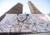 Un cartellone realizzato dall’artista ravennate Gianluca Costantini per la liberazione di Patrick Zaki sulla torre di Bologna
