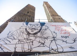 Un cartellone realizzato dall’artista ravennate Gianluca Costantini per la liberazione di Patrick Zaki sulla torre di Bologna