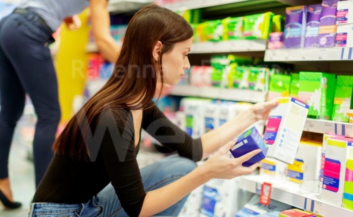 Young woman taking time choosing sanitary panty liners