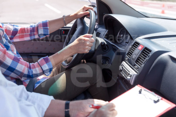 Learner driver student driving car with instructor