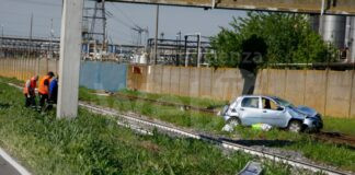 Auto esce di strada, abbatte albero, cappotta e si ferma sui binari