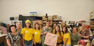 Magliette gialle impegnate in due laboratori per la realizzazione di cuscini terapeutici e bustine porta drenaggio