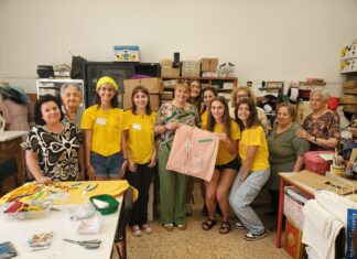 Magliette gialle impegnate in due laboratori per la realizzazione di cuscini terapeutici e bustine porta drenaggio
