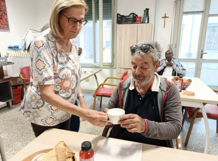 Una volontaria e un ospite in sala colazioni